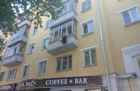 В центре Тулы женщина выбрасывает вещи с балкона